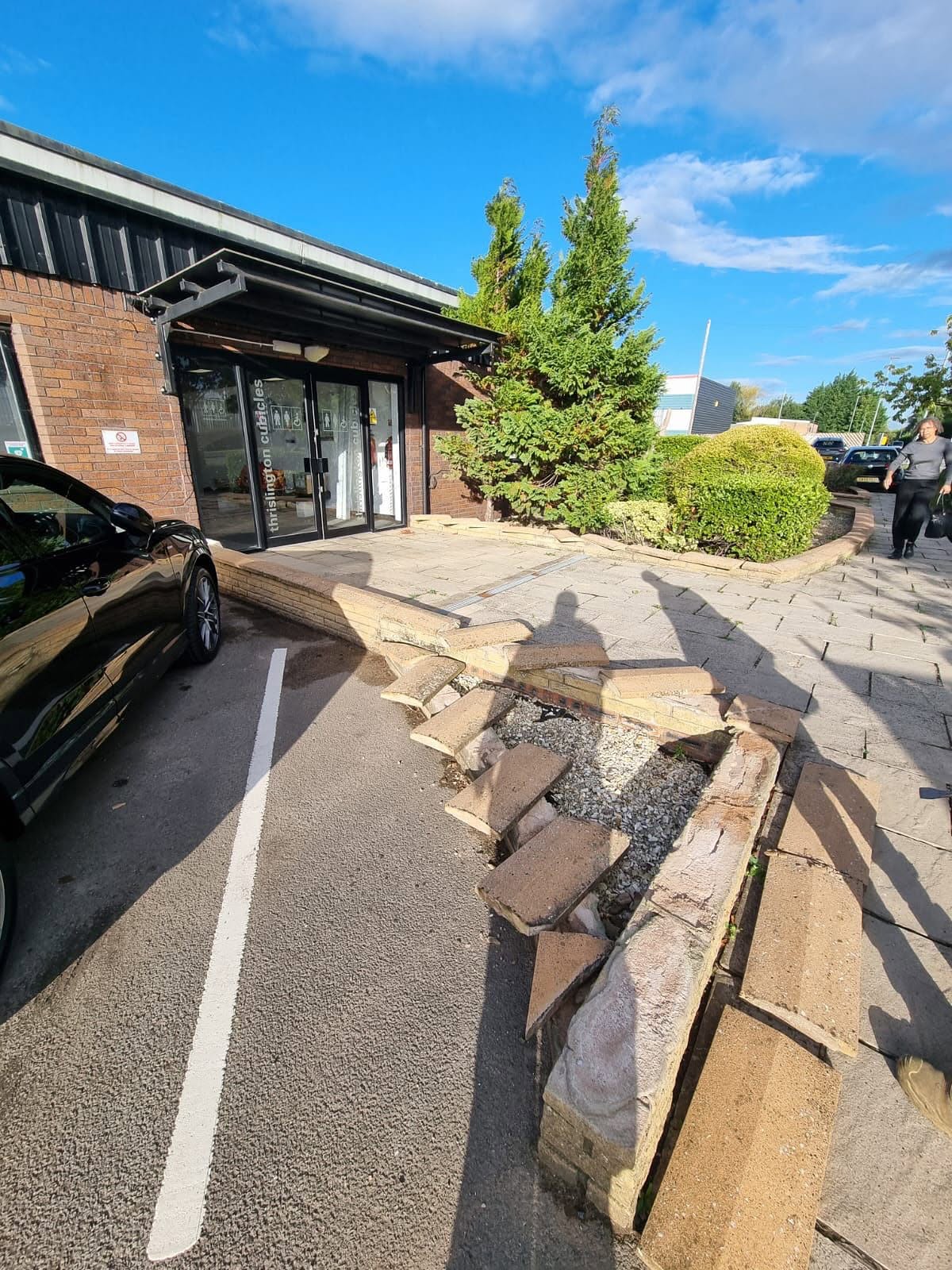 Damaged stone wall and coping repaired in a commercial car park