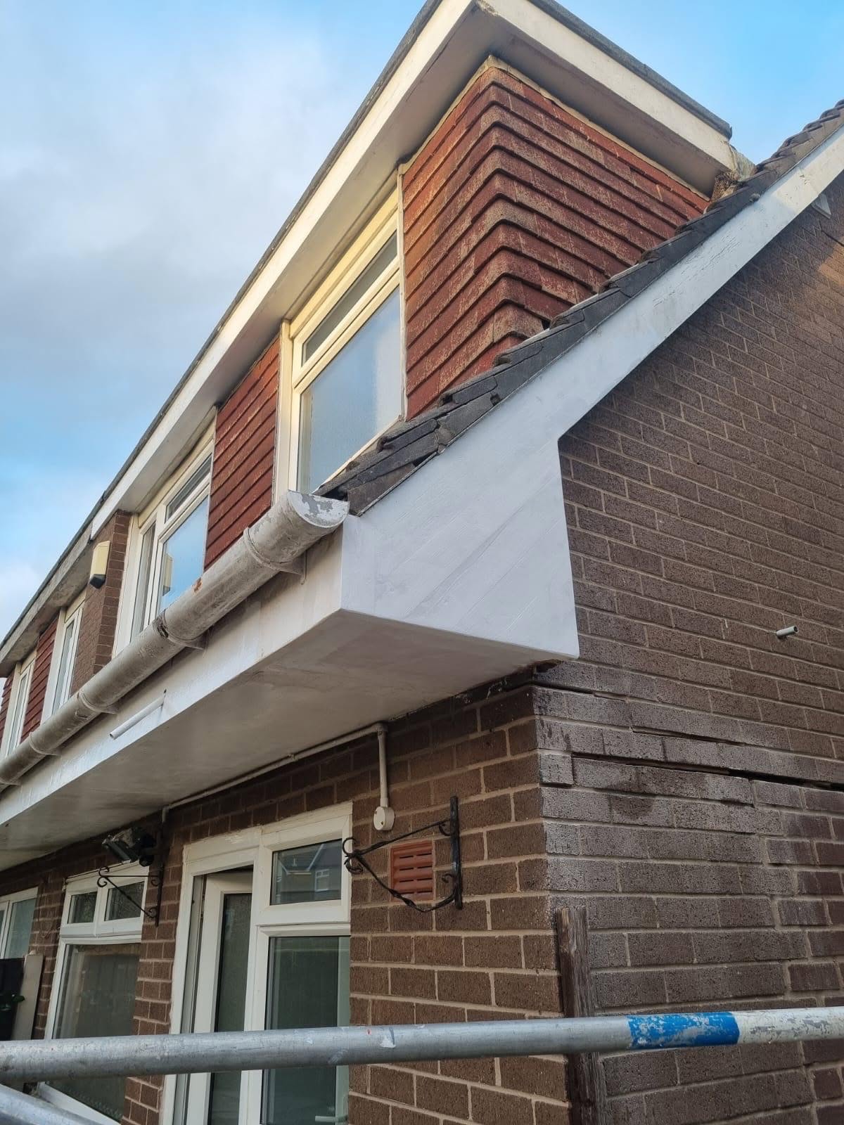 Repaired and freshly painted roof fascia, soffit and gutter on a UK property
