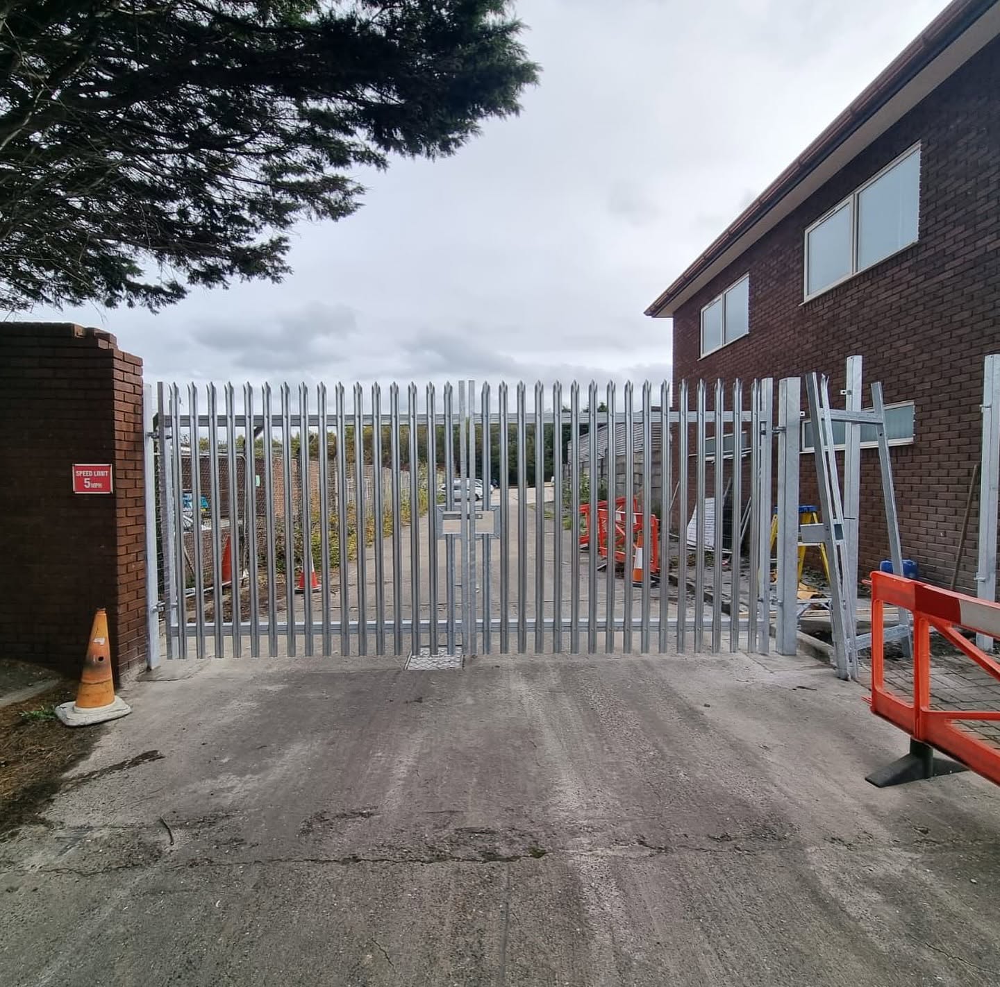 Newly installed steel palisade security gate beside a building
