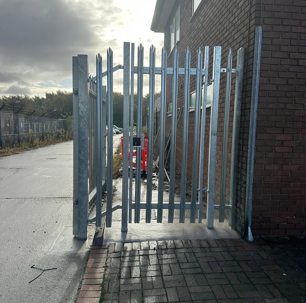 Steel palisade security gate fitted with heavy-duty lock hardware